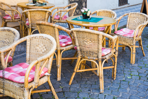 Old Fashioned Cafe Terrace Tables And Wicker Chairs In A