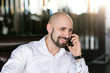 © fotofrol - A brutal bald man talking on the phone.