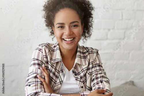 Positive Mixed Race Female With Curly Dark Hair And Gentle Smile