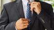 Businessman adjusting his tie with fitted suit for start working, blurred focus and vintage tone