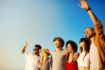 Wall Mural - Group of happy friends having fun at ocean beach