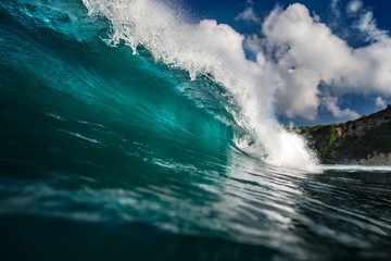 Fototapete - Blue Ocean Wave Crashing near rocky wall