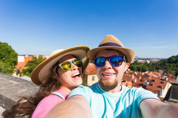 Wall Mural - Happy young couple in love takes selfie portrait in Prague, Czech Republic. Pretty tourists make funny photos for travel blog in Europe.