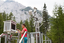 Pretty Woman Meteorologist Reading Meteodata Instruments In Modern Meteorologic Observation Station, High In Mountains