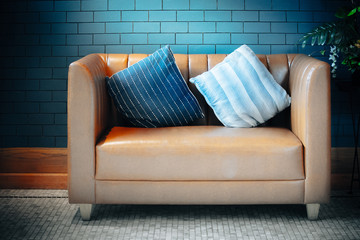 Brown sofa with two pillow decoration in living room.