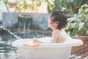  asian  child bathing in the garden