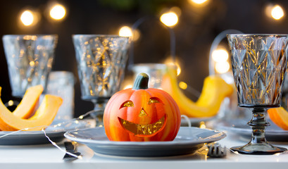 Halloween pumpkin at dishes on dinner