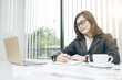 © somchaikhun - Modern asian business woman working in office with copy space and sun rise.
