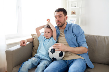 Poster - father and son watching soccer on tv at home