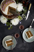 Marzipan Almond Cake With A Orange Blossom Mascarpone Frosting On A Wooden Pedestal, Served With Rosé Wine.  Photographed On A Black/gray Background.