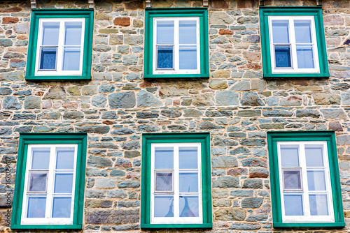 Fotografie, Obraz Closeup of european architecture stone building with green window frames