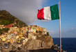 Manarola village in Cinque Terre with italian flag in foreground