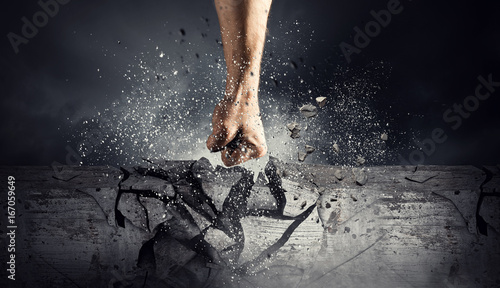 Fotografía Hand breaking through the wall. Mixed media