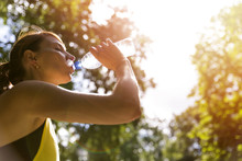 Young Beautiful Brunette Drinking Water From A Bottle After Running Workout