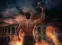 Back View Of Muscular Man Holding Burning Trophy Cup, Antique Colosseum On Background.