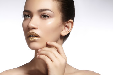 Wall Mural - Young Beautiful Woman with clean soft Skin, bright gold Lips Makeup. Perfect eyebrows shapes. Day make-up