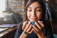 A Beautiful Asian Woman Drinking Hot Coffee Or Tea From Vintage Cup In Modern Loft Cafe