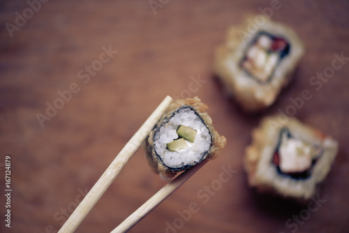Cuadros en Lienzo Rodillos de sushi japonés en un soporte de madera