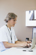 © Cavan Images - Female doctor using laptop in hospital