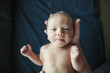 © Cavan Images - Overhead portrait of newborn baby boy held by father in hospital
