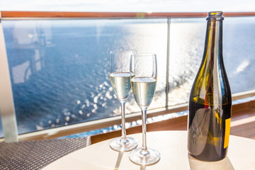 champagne bottle and flutes glasses on luxury cruise travel for honeymoon holidays. boat at sea on v