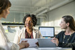 © Cavan Images - Smiling businesswomen discussing over tablet computer while sitting in office