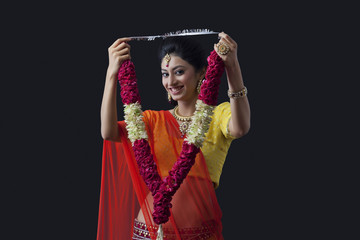 Wall Mural - Portrait of a smiling bride holding a garland