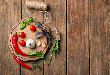 Wall Mural - Composition with fresh herbs and vegetables on wooden background