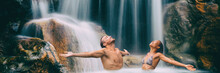 Nature Couple Relaxing Under Waterfall With Open Arms In Freedom Banner. People Enjoying Water Falling In Natural Pool In Tropical Nature. Wellness, Health And Spa. Wide Landscape Crop For Panorama.