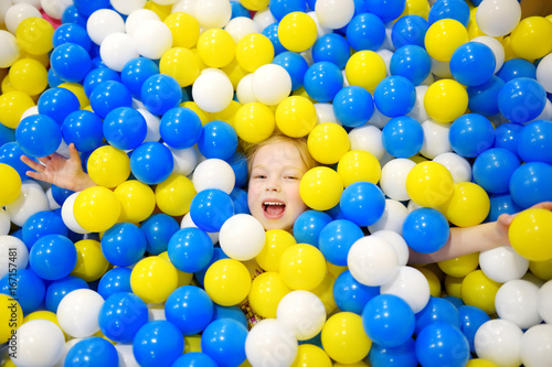 Happy Little Girl Having Fun In Ball Pit In Kids Indoor Play