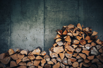 chopped logs for winter fire. Pile of firewood against old wooden fence