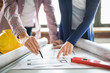 © REDPIXEL - Architects working with blueprints in the office.