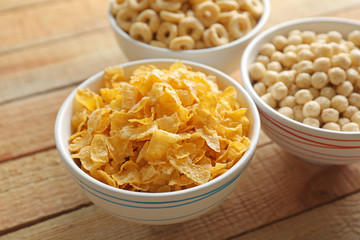 Wall Mural - Bowls with different healthy breakfast cereals on wooden background