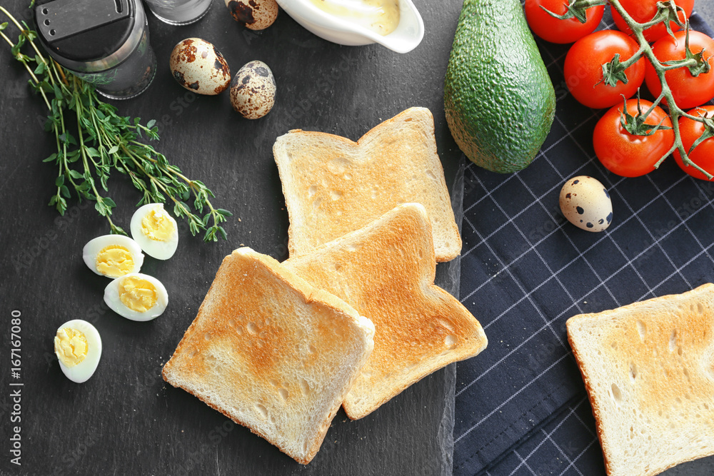 Slate plate with tasty breakfast toasts on table