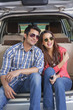 © IndiaPix - Young man and young woman sitting in the trunk of a car