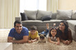 © IndiaPix - Happy family with pug posing on carpet in living room