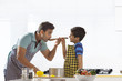 © IndiaPix - Father and son tasting soup while cooking in kitchen