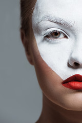 Wall Mural - cropped view of beautiful teen girl with creative white bodyart on face, isolated on grey