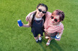 © LIGHTFIELD STUDIOS - high angle view of young multiethnic women in sunglasses holding soda cans and smiling at camera