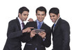 © IndiaPix - Businessmen looking at a mobile phone