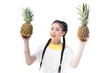 © LIGHTFIELD STUDIOS - attractive asian girl holding two pineapples and smiling at camera isolated on white