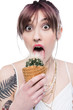 © LIGHTFIELD STUDIOS - shocked young woman licking sharp cactus in waffle cone and looking at camera isolated on white