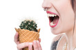 © LIGHTFIELD STUDIOS - hungry young woman eating cactus in waffle cone isolated on white