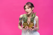 © LIGHTFIELD STUDIOS - sensual young woman holding ripe pineapples and looking at camera isolated on pink