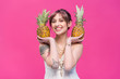 © LIGHTFIELD STUDIOS - happy attractive girl holding ripe pineapples and smiling at camera isolated on pink