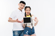 © LIGHTFIELD STUDIOS - smiling young asian couple holding digital tablet with blank screen isolated on white