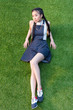 © LIGHTFIELD STUDIOS - beautiful young asian woman lying on green grass and looking away