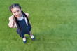 © LIGHTFIELD STUDIOS - beautiful smiling asian girl pointing at camera with finger while standing on green grass