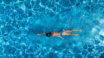 Wall Mural - Aerial top view of woman in swimming pool water from above, tropical vacation holaday concept
