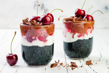 Wall Mural - Healthy Black Forest dessert. Black activated charcoal chia pudding with cherries, coconut cream and chocolate. Vegan creamy breakfast.